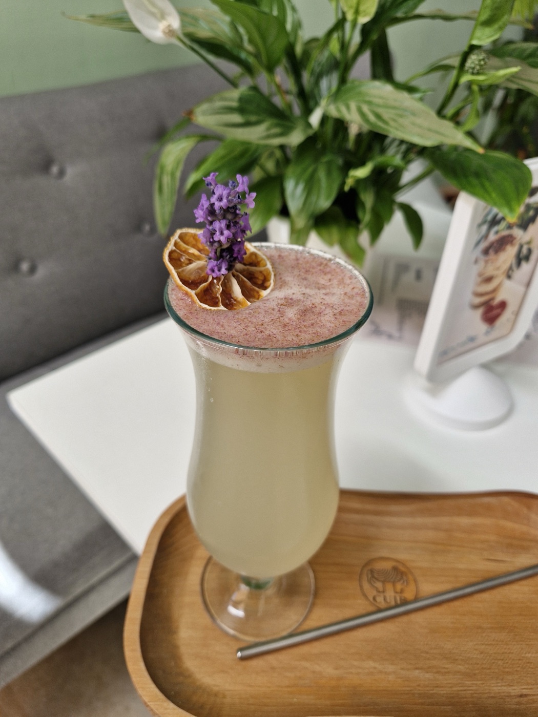 Limonadă cu lavandă într-un pahar înalt, cu o felie de lămâie uscată și un fir de lavandă